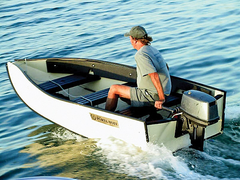 Man with hat hand steering boat in water