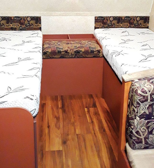 Twin beds in RV with nightstand between them