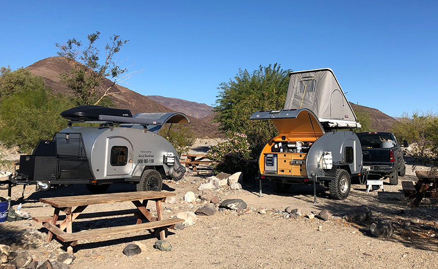 Two So-Cal Teardrops Kascade tiny trailers side by side in campsite