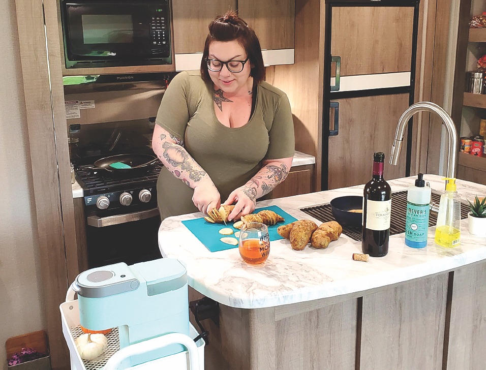 woman cutting food in her RV's kitchen