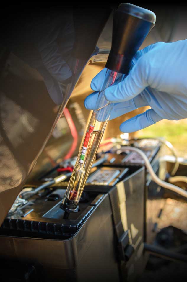 Electrolyte is drawn out of the cell of a wet-cell battery and into a hydrometer so the specific gravity and cell voltage can be measured. This battery is in the red zone, indicating that it needs to be charged.