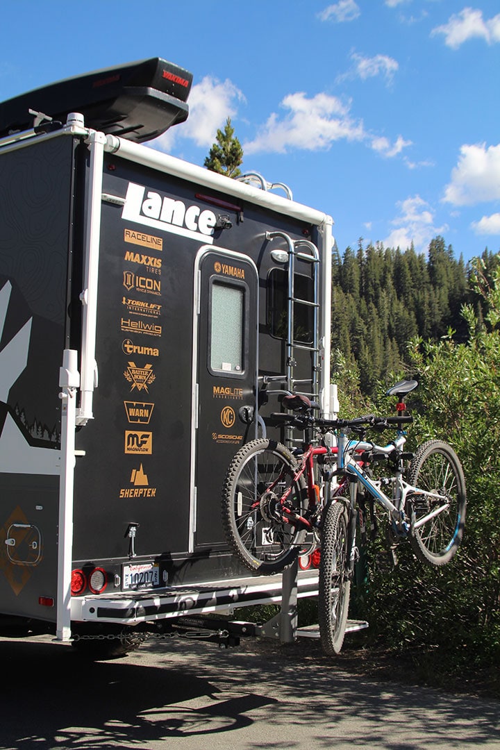 Rear of truck camper with Yakima bicycle rack and roof-mounted Rocket Box.