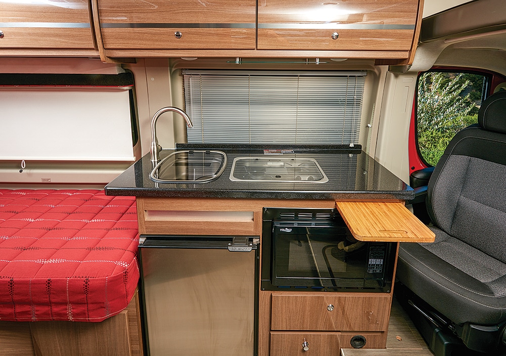 The attractive galley has good counterspace and everything needed to prep a meal is within easy reach. The pullout cutting board doubles as a dining table. 