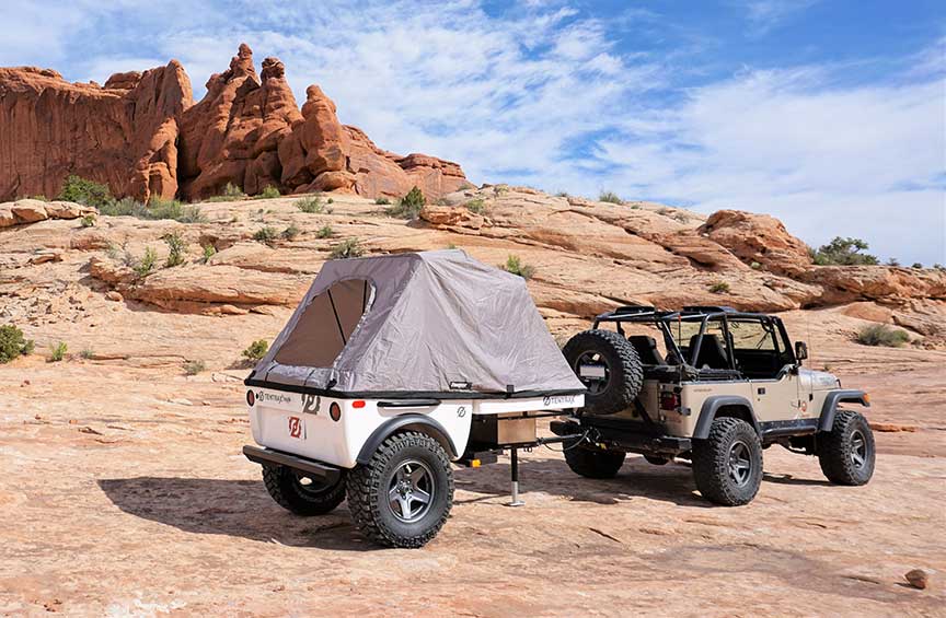 Tentrax trailer and Jeep in front of redrock pinnacles.