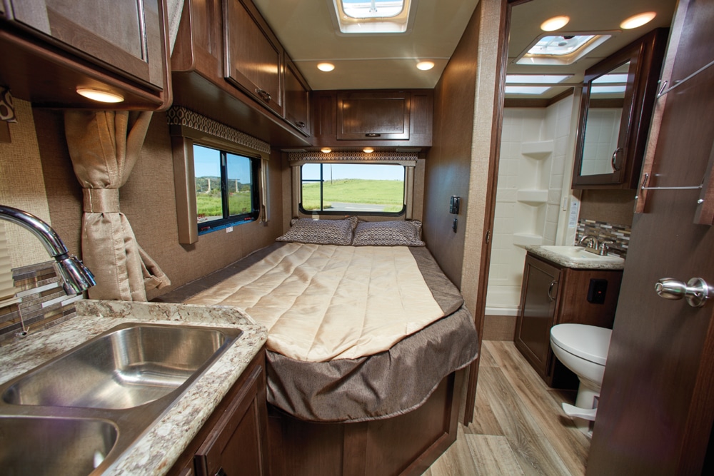 Large windows add an open feel, and a privacy shade closes the bed off from the galley. The end of the bed is cut at an angle to allow wide entry into the bathroom.