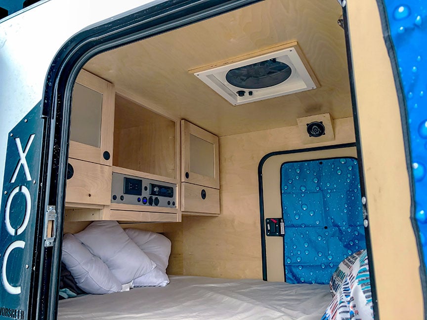 Interior of XOC showing birch paneling and cabinets and bed.