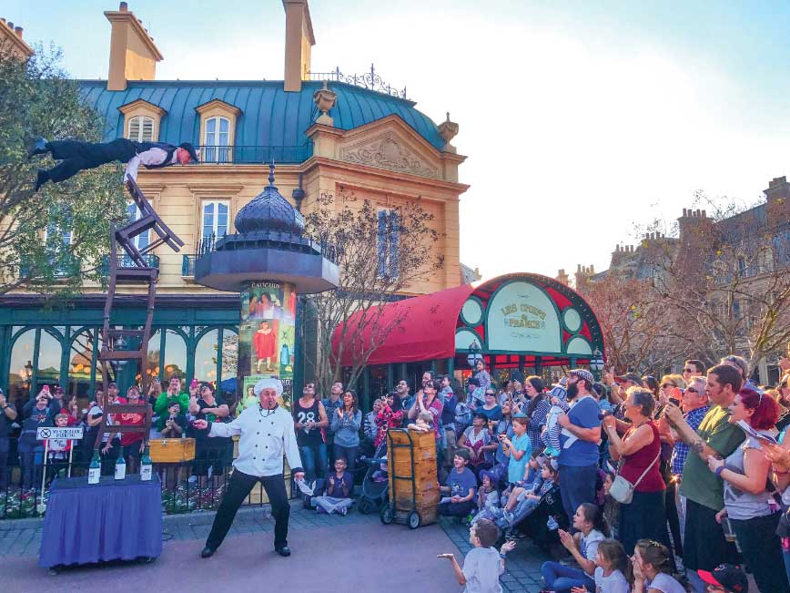  the Puglisi family catches some street entertainment at Epcot’s World Showcase