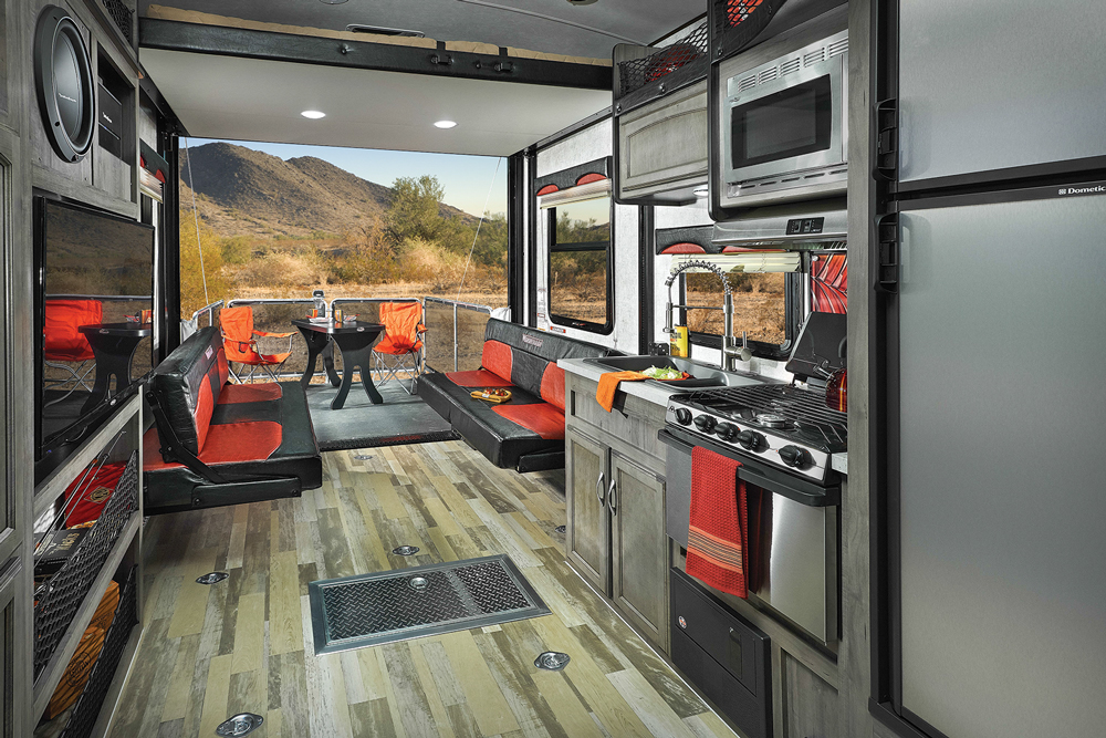 Opposing sofas make into a large bed; the HappiJac bed lift reveals a queen-size bed. The kitchen is compact but workable.