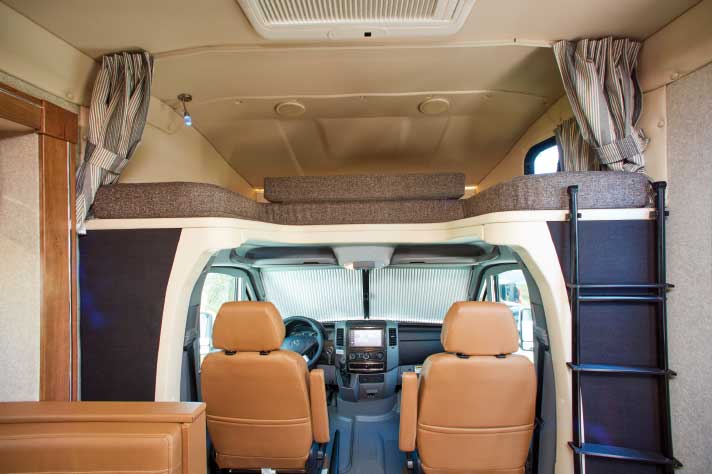 Cabover area is utilized for additional sleeping positions. Center section can be removed and placed on front portion of cushion to open cockpit headroom. Ladder is stored to the side when not in use. Sprinter cab is all business, featuring ergonomic controls and instrumentation.