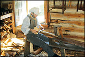 Man woodworking in cabin