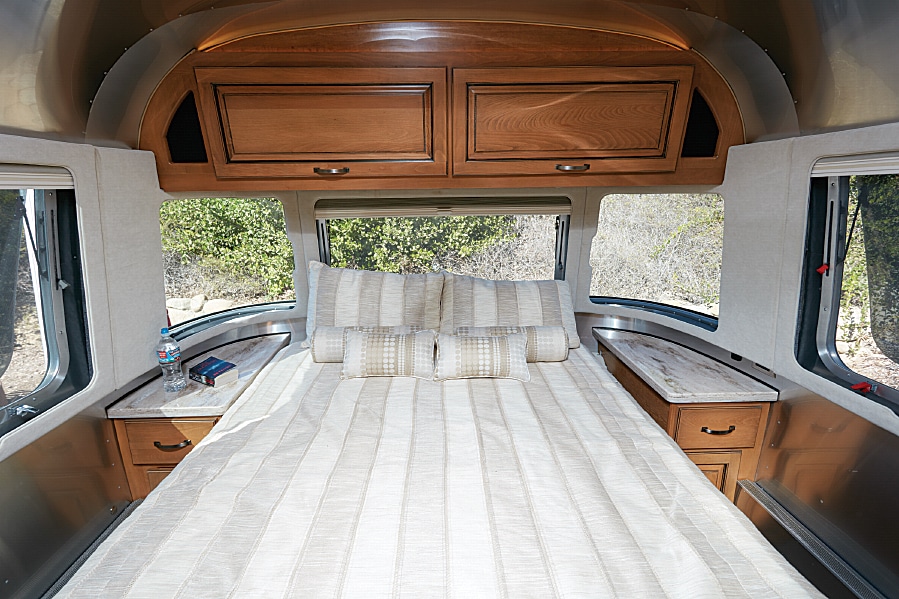 Windows surround the walk-around queen pillow-top memory-foam mattress. Controls raise and lower the head of the bed.
