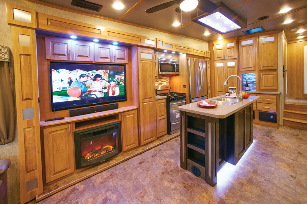 Galley users have easy access to all appliances. An adjacent 50-inch TV with a fireplace below is directly across from theater seating.