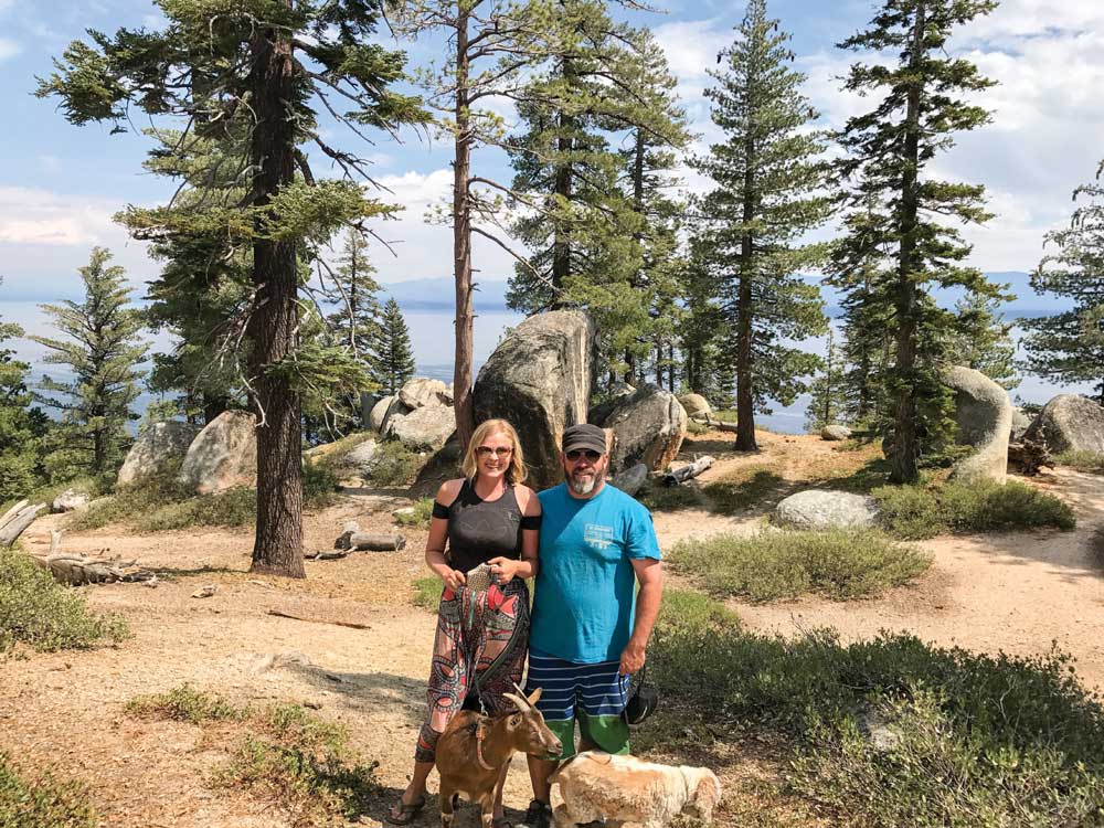 husband, Chad, enjoy the view of Lake Tahoe with their pet goat, Frankie, and pup, Maggie.