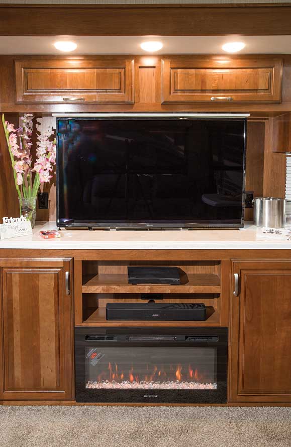 The 50-inch LED TV is on a lift and lowers into the cabinet behind the Greystone electric fireplace. A Bose Bluetooth soundbar and Samsung Blu-ray disc player offer theater-quality sound.