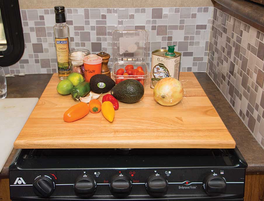 A cutting board stove cover adds extra space to an RV galley