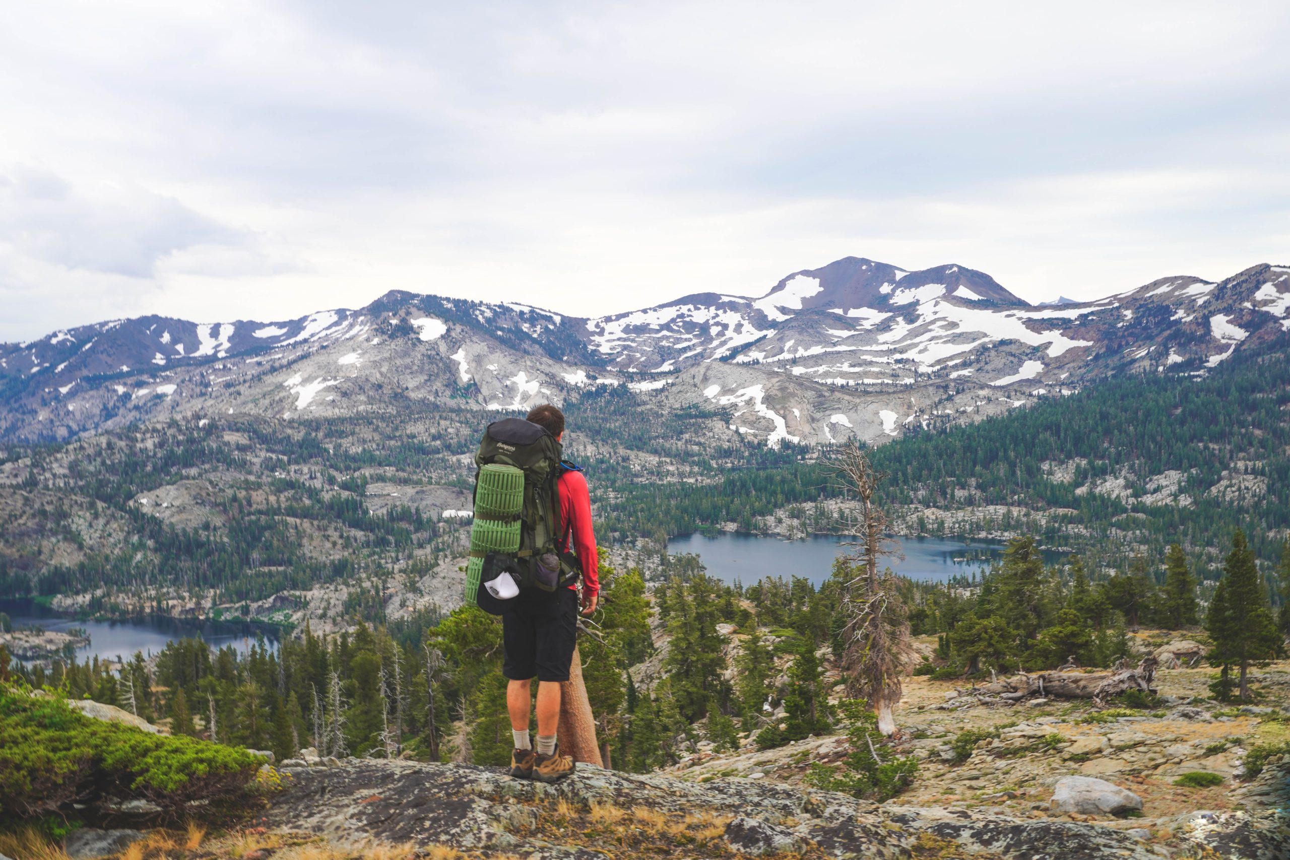 Hiker standing on ledge looking over Lake Tahoe