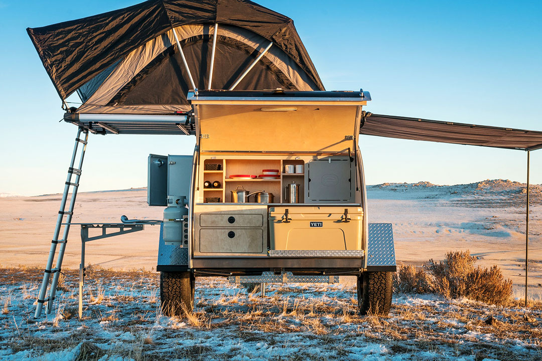 Rear view of Escapod Top trailer with galley hatch open and rooftop tent extended.