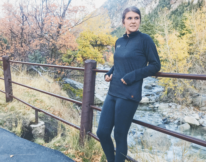 Young woman leaning against railing in fall colored forest