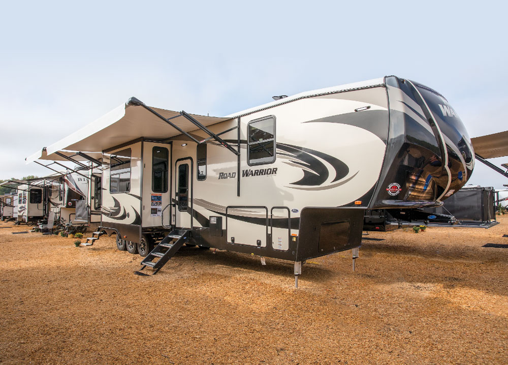 Beige and brown designed Heartland Road Warrior travel trailer with awning out