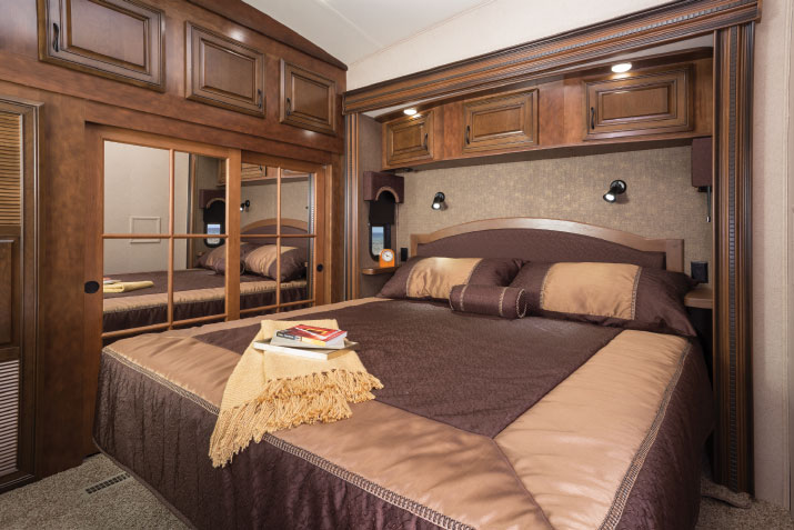 Overhead cabinets, built-in nightstands and the king-size bed’s hardwood headboard tuck into the front-bedroom slide.