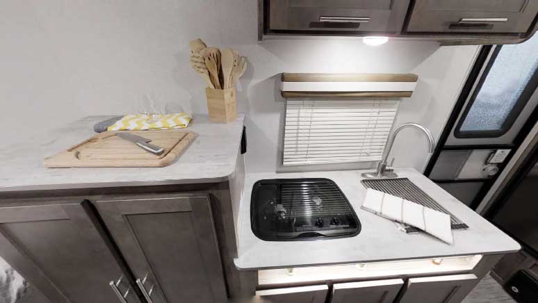 The kitchen’s roll-up stainless-steel sink cover doubles as a dish rack, food tray or trivet.