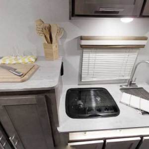 The kitchen’s roll-up stainless-steel sink cover doubles as a dish rack, food tray or trivet.