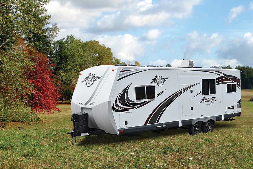 White Arctic Fox fifth wheel RV parked outside