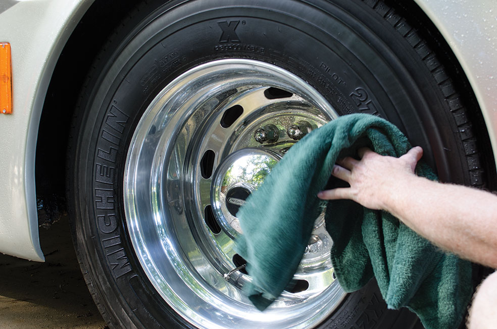 Man drying RV tire with towel