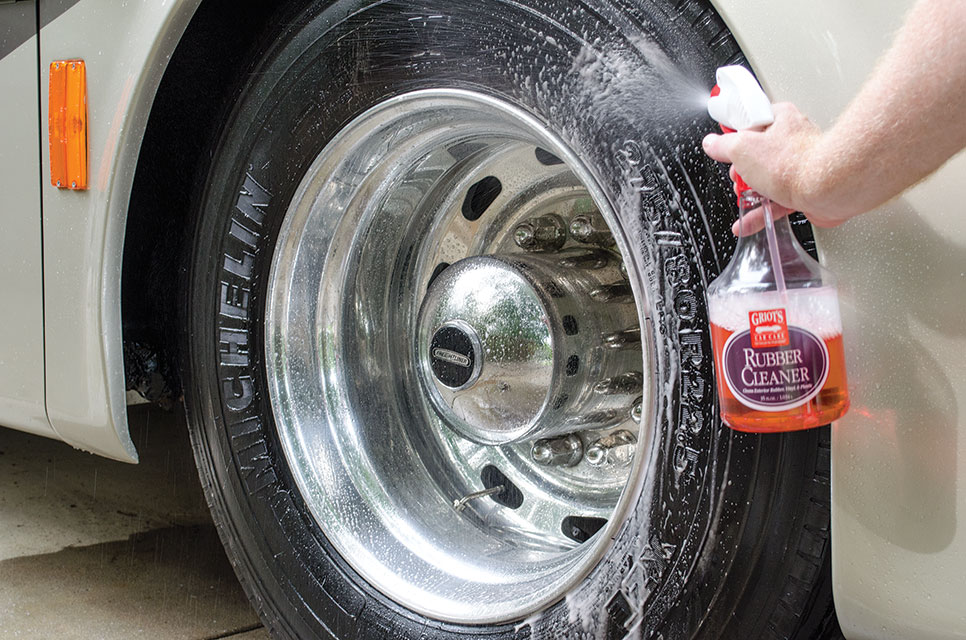 RV tire with man spraying tire cleaner 