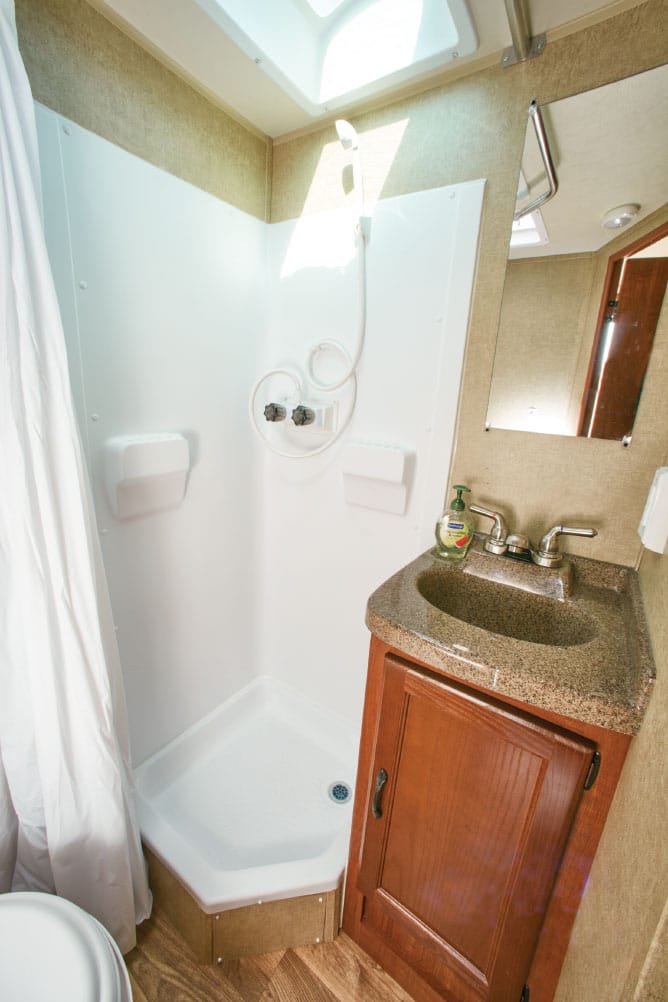 The i18’s neo-angle shower opens up floor space in front of the sink and around the toilet. The lavatory features a large medicine cabinet (not shown) and a Granicote counter.