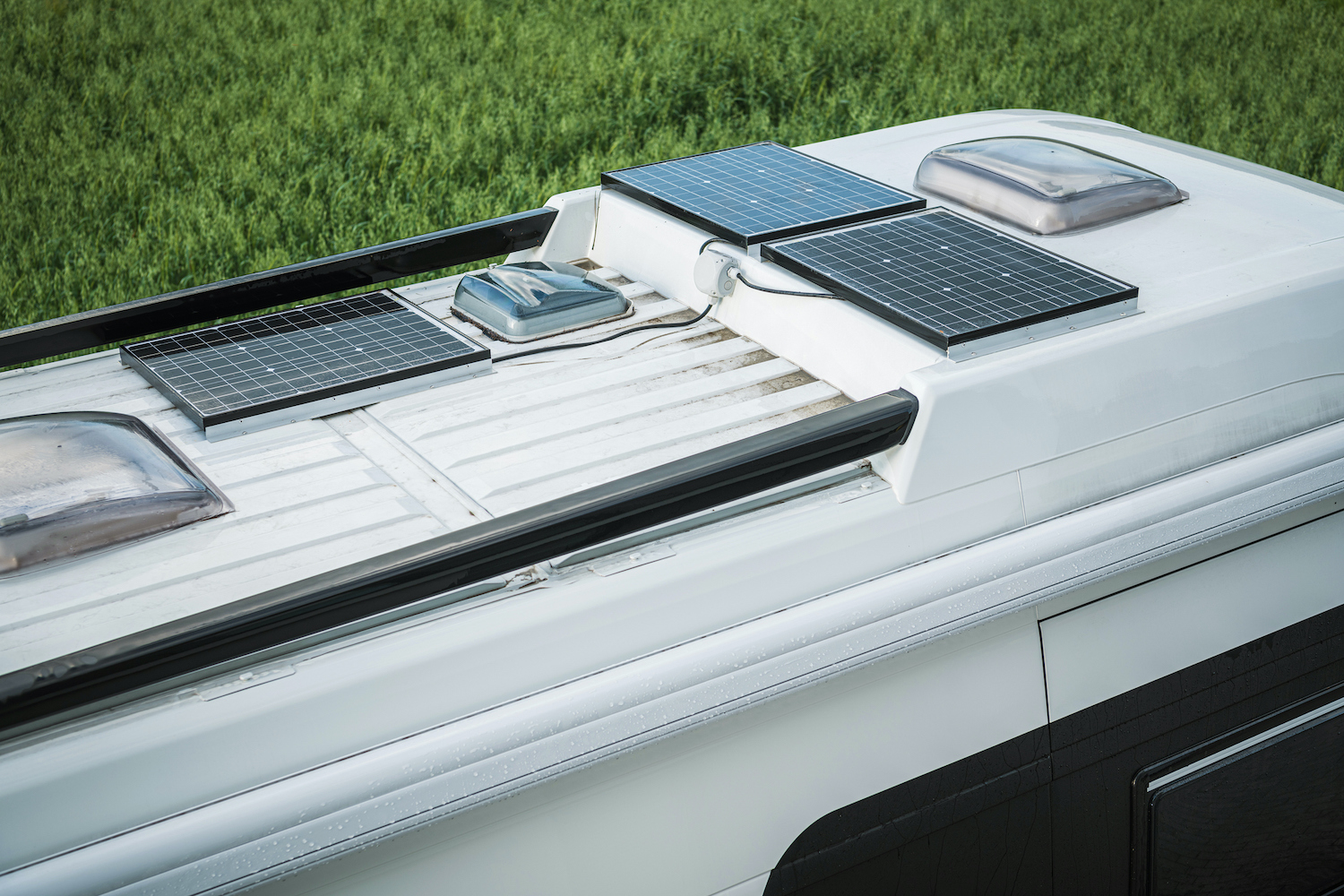 Close View Of Parked Camper Van With Three Solar Panels On Top Of Roof.