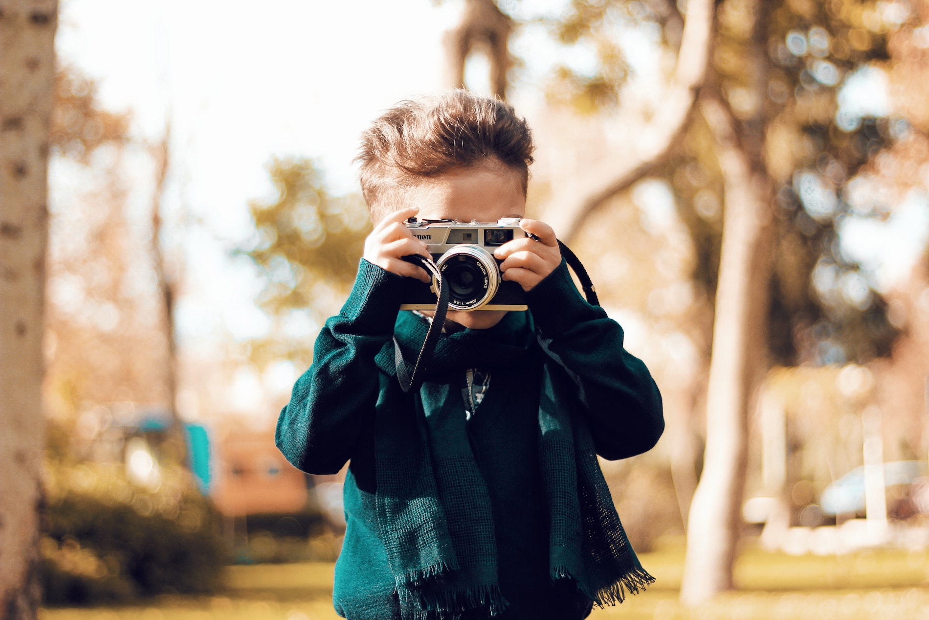 A young kid taking a photo