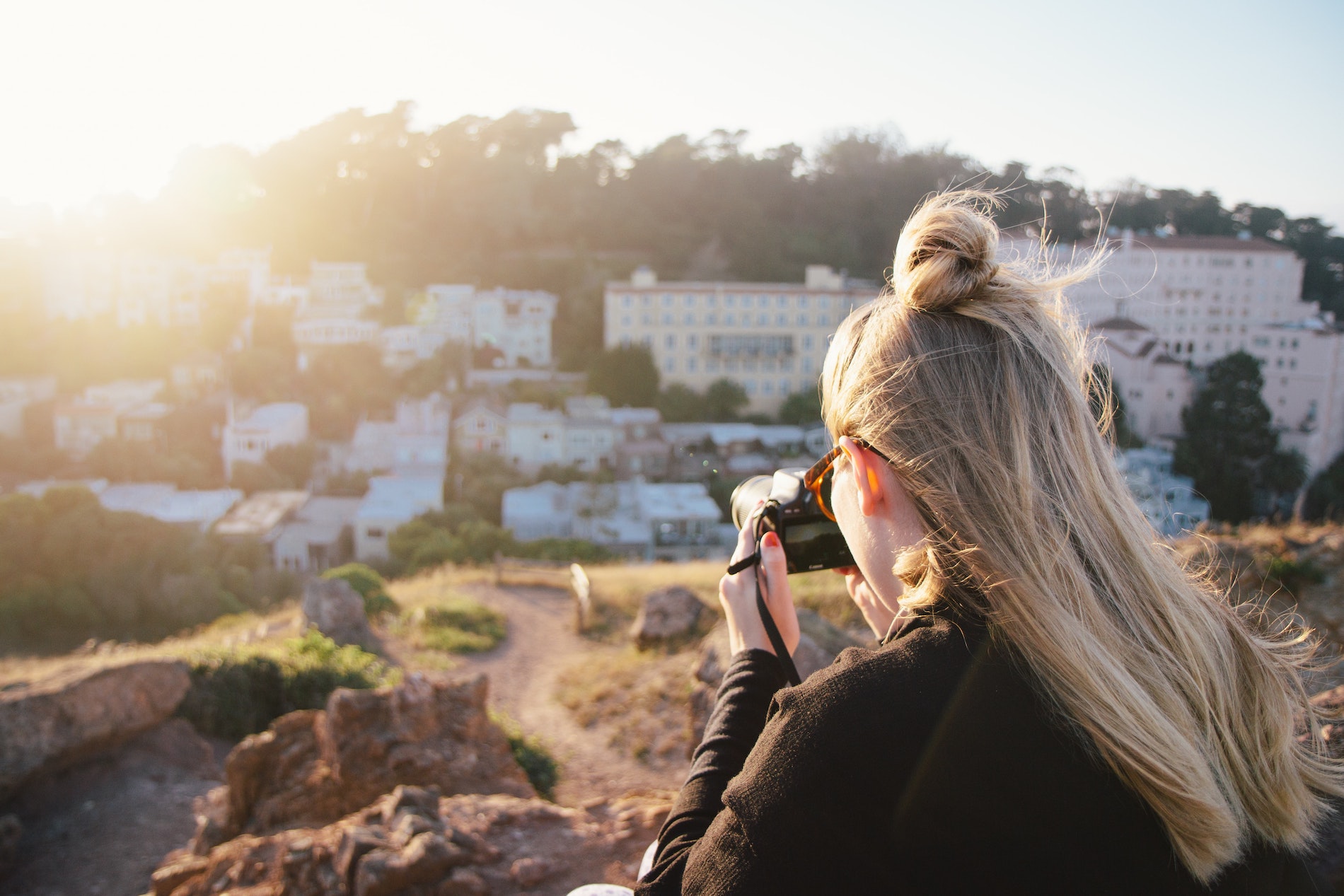 a girl taking a photo facing the sun