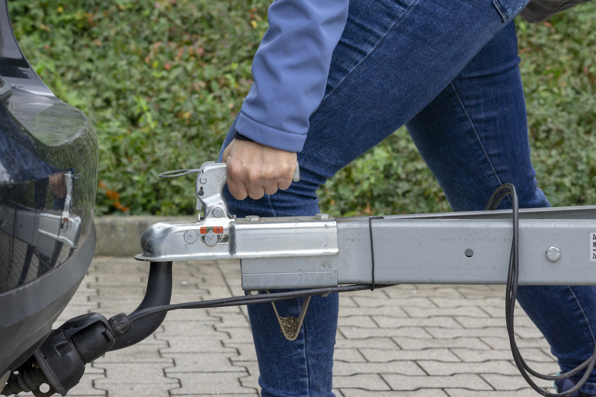 woman couple a trailer (i.s., "hooked") into a ball-type tow hitch