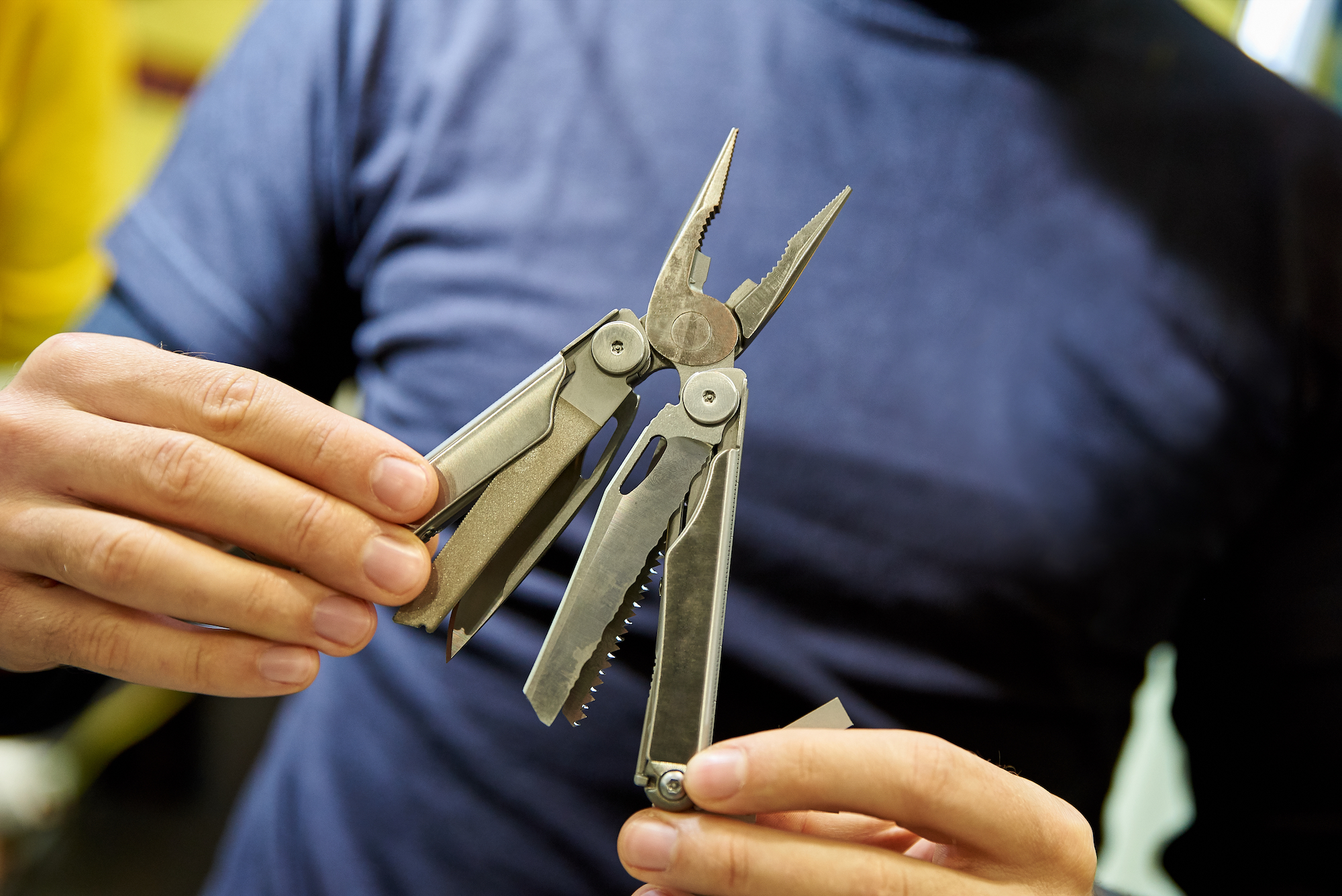 knife multitool turned into pliers in the hands of a man