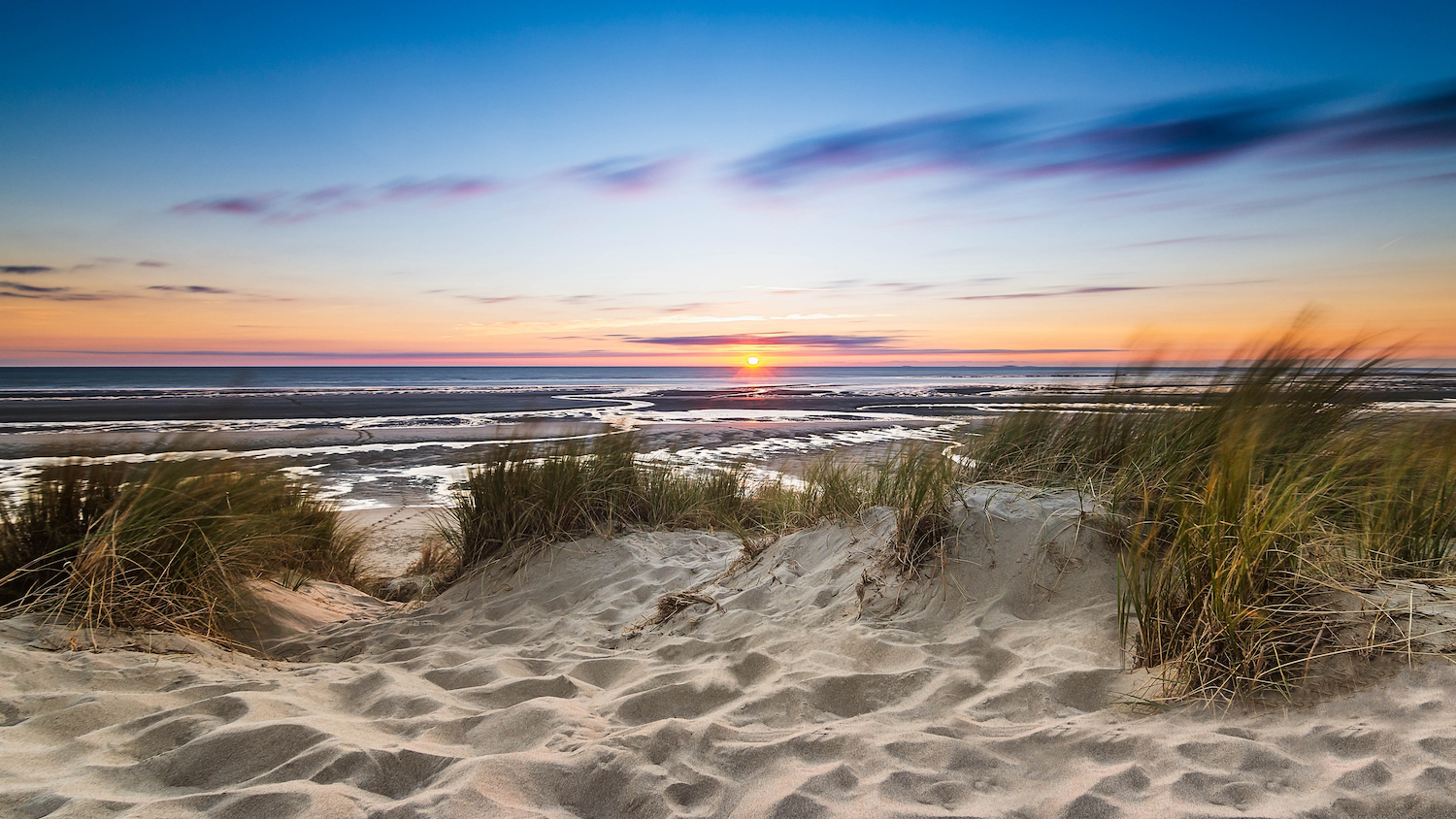 Sunset over sand dune and beach
