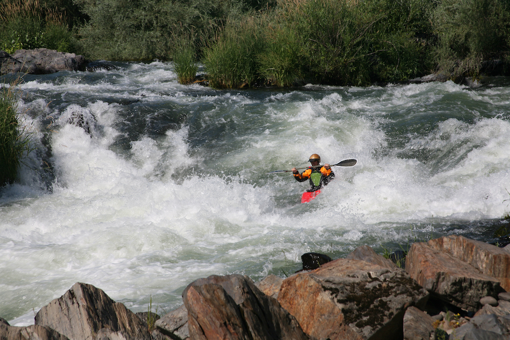 A kayaker battling strong rapids on the Rogue River in Oregon