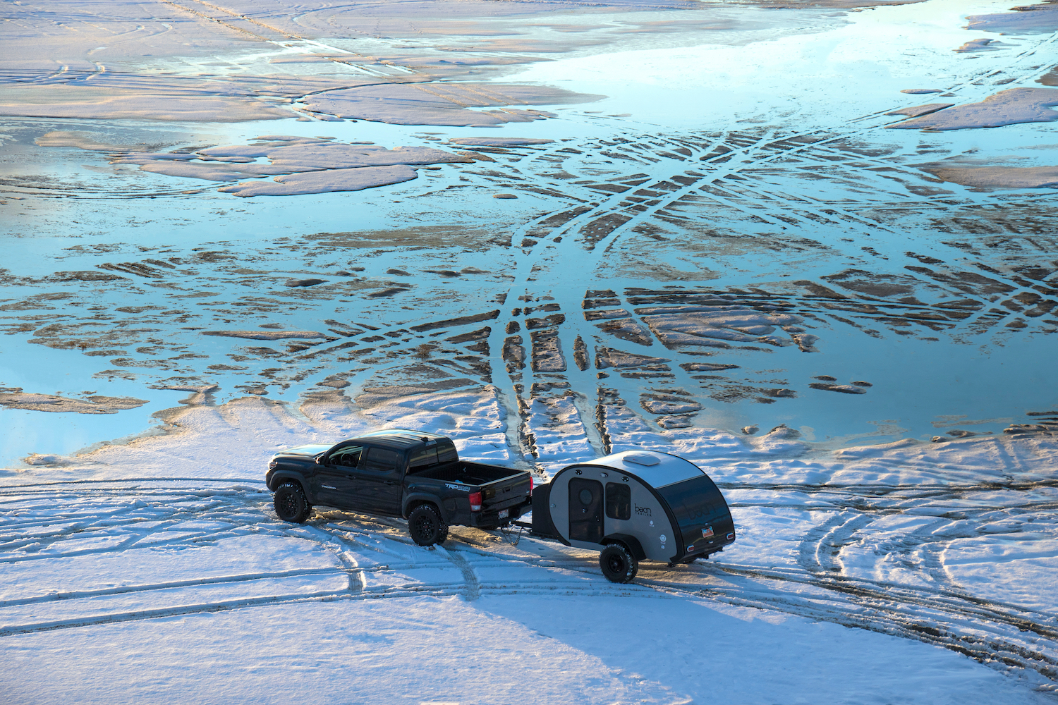 THE GREAT SALT LAKE, UTAH / UNITED STATES - January 23, 2019: Toyota Tacoma Pulls Teardrop Trailer onto Frozen Lake