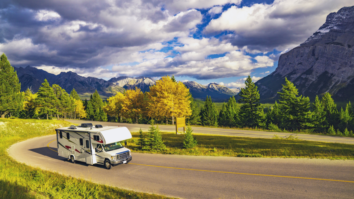 Recreational Vehicle Driving on Autumn Highway In Beautiful Mountains Wilderness