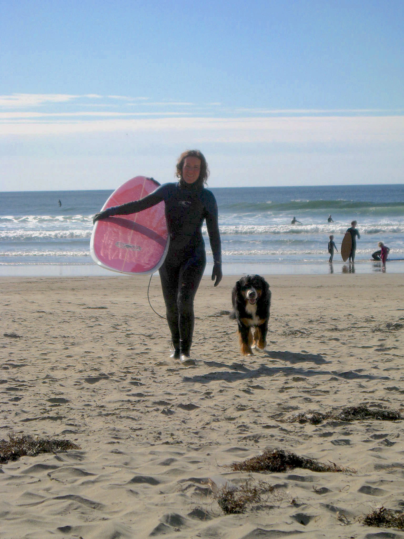 Ariel Frager with surfboard and dog.
