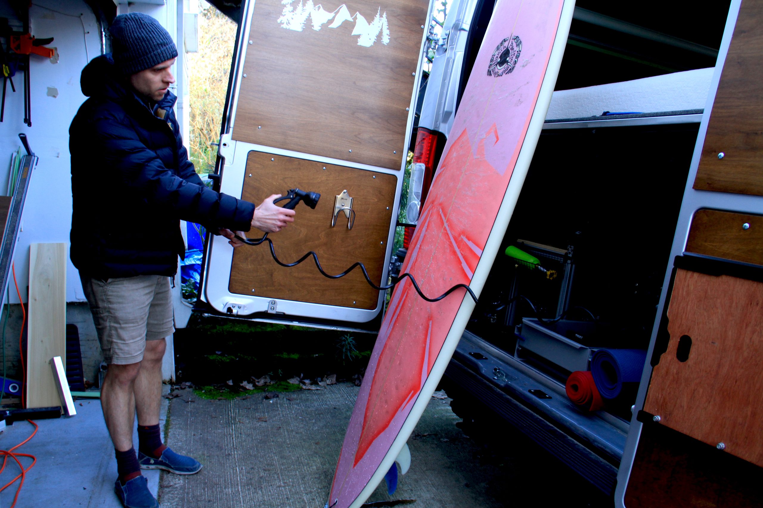 washing off surfboard against van