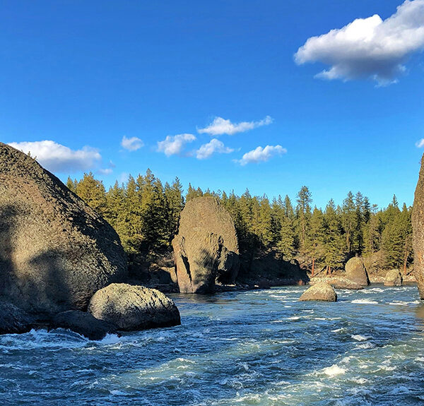 Churning river flanked by tall cliff faces.