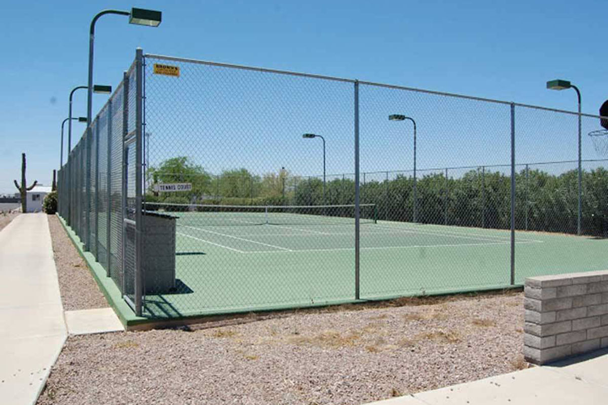 Tennis court surrounded by chain-linked fence.