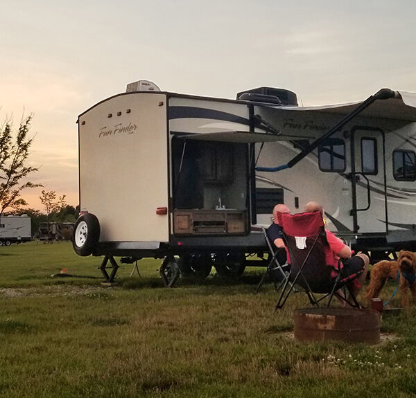 A family outside of RV at campsite.