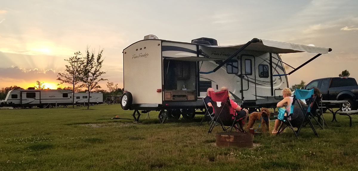 A family outside of RV at campsite.