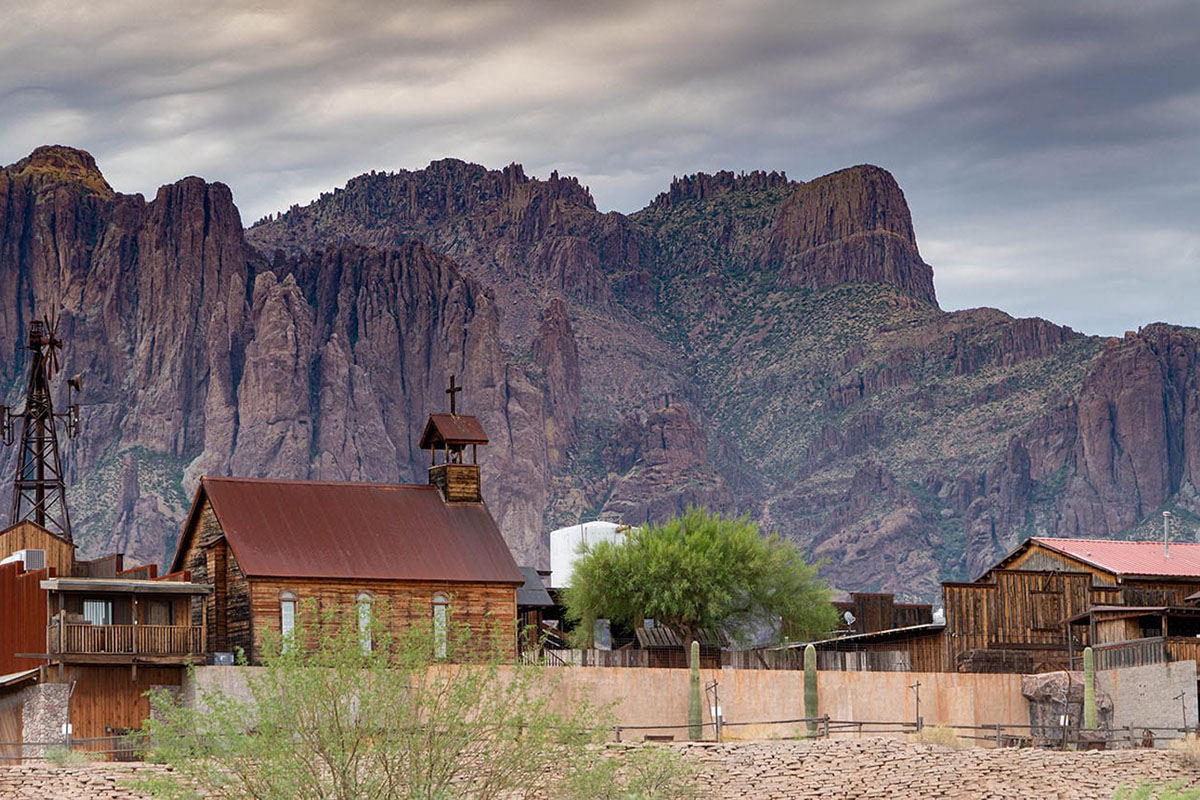 A ghost town against a backdrop of mountains.