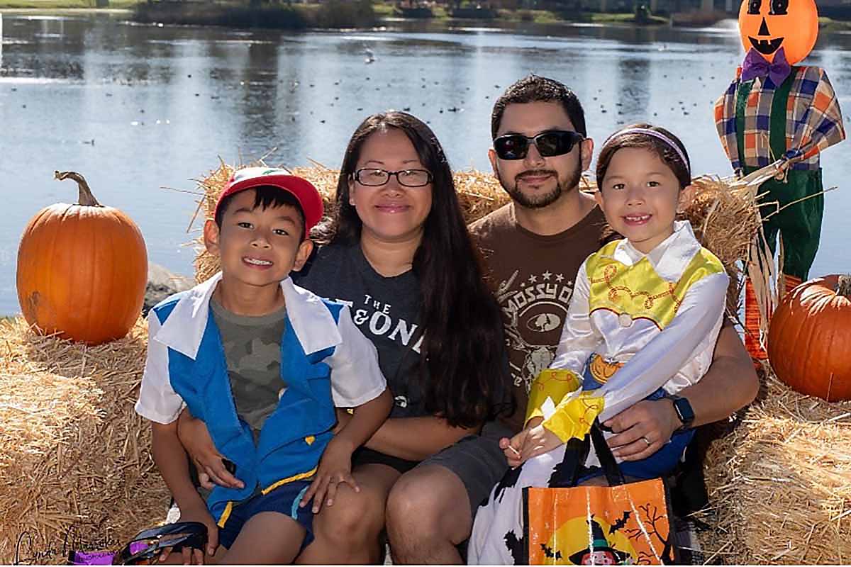 A family surrounded by Halloween decorations.