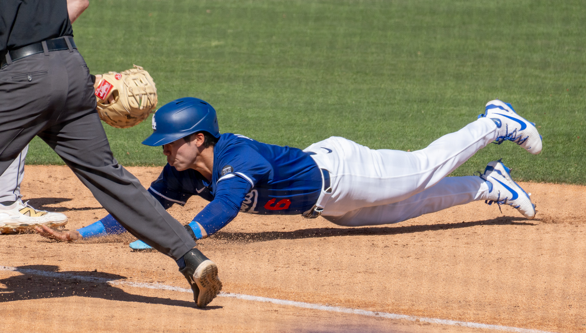 Player in blue jersey slides into home.