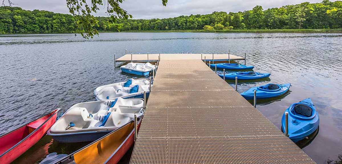 Kayaks and boats moored to a dock.