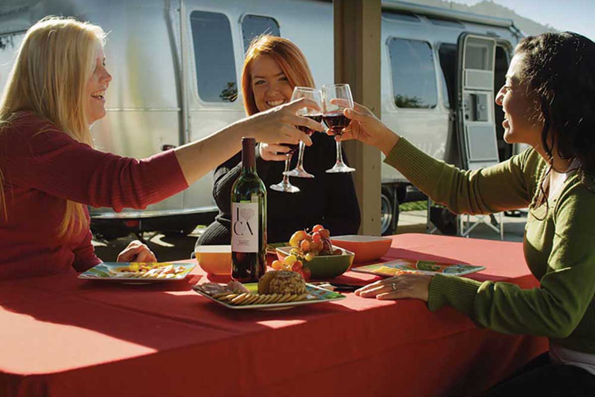 Three women at a table tasting wine.